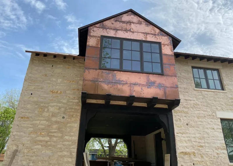Copper metal panel facade on a stone building for Roof Repair in Meadowbrook