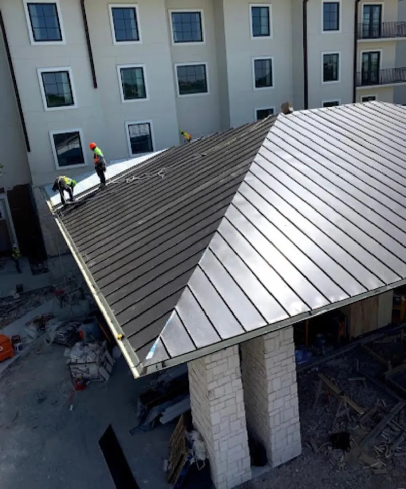 Crew installing standing seam metal roof panels on a commercial project in Meadowbrook